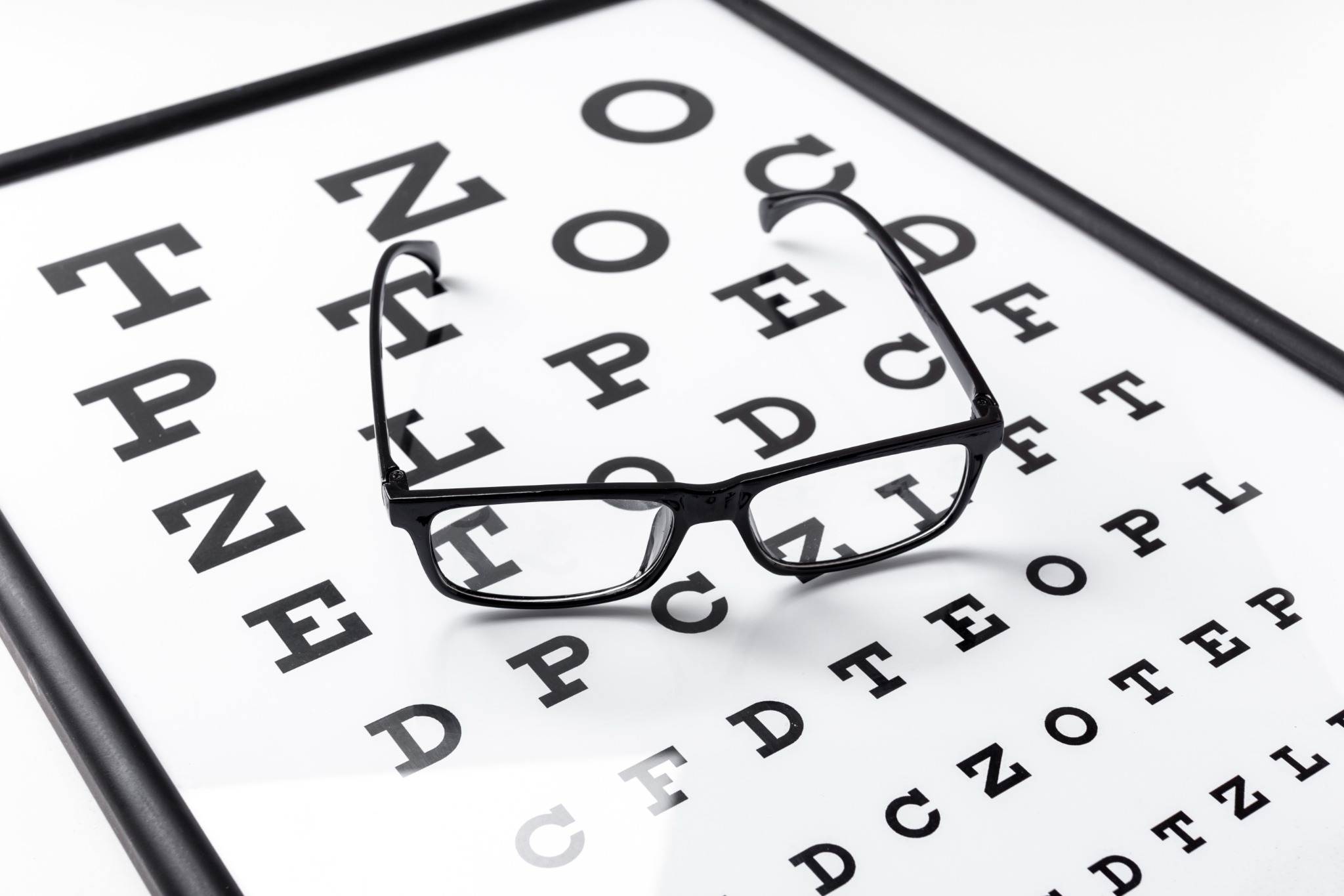 Óculos sobre tabela de letras para exame de vista